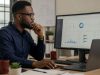 Nigerian marketing professional reviewing website search performance data on a desktop monitor in a modern office.