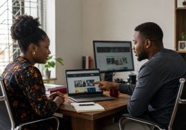 A Lagos business owner and web design consultant reviewing website mockups together during a project consultation.