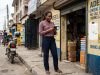 Lagos business owner checking her shop's Google Maps listing on her phone outside her storefront.